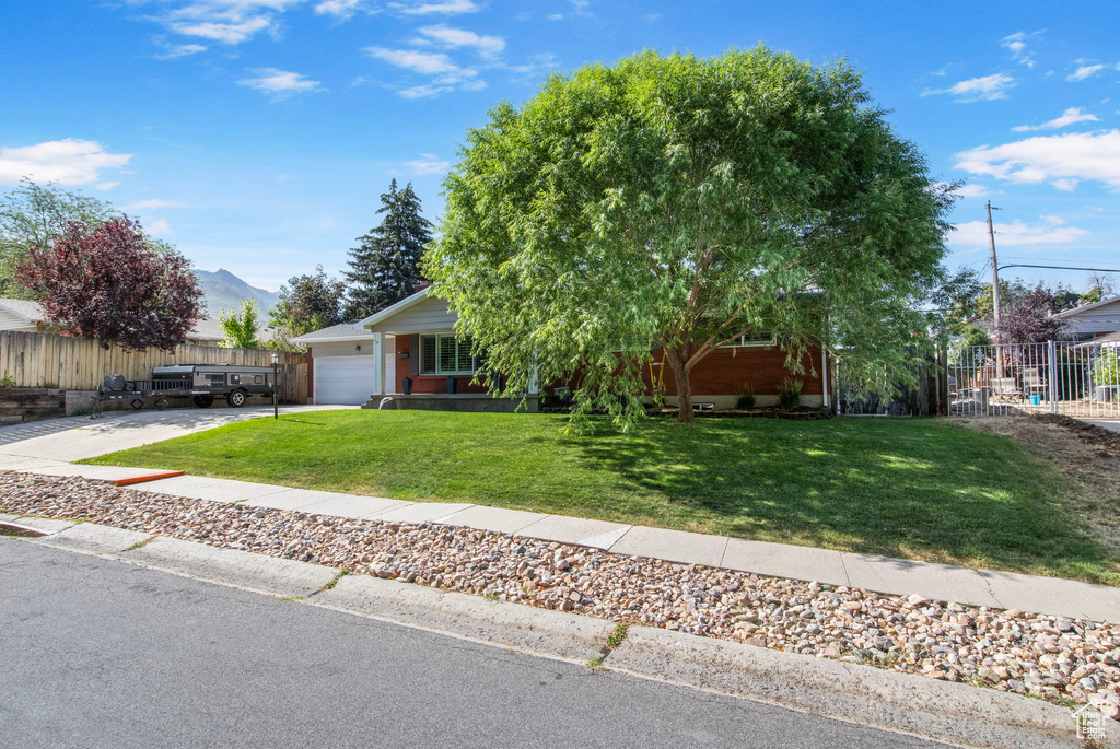 Obstructed view of property featuring an attached garage, concrete driveway, and a mountain view