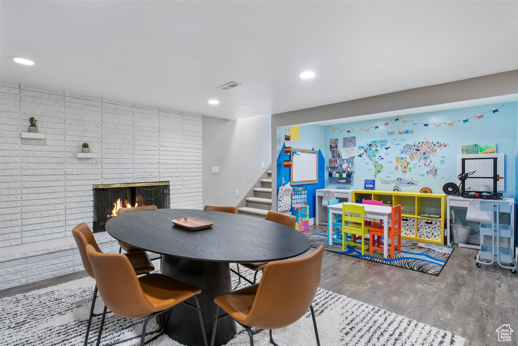 Dining area featuring stairs, wood finished floors, a fireplace, and recessed lighting