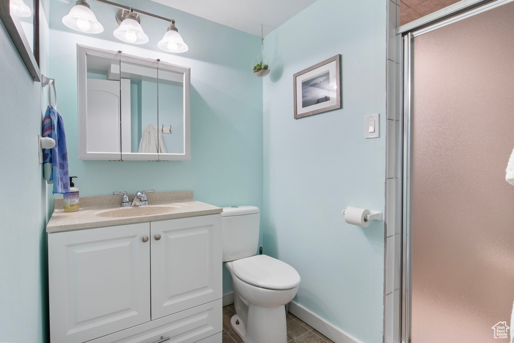 Bathroom with a shower stall, vanity, and tile patterned flooring