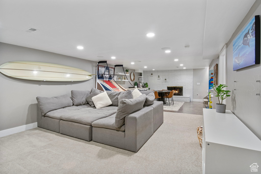Carpeted living area with recessed lighting and a brick fireplace