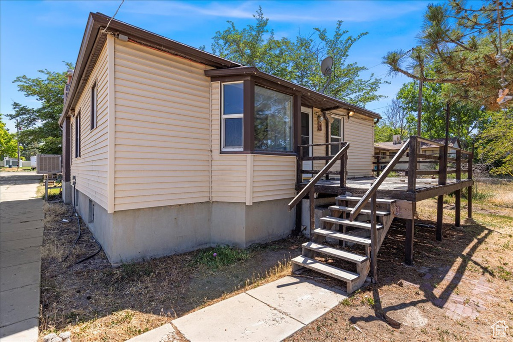 View of side of home featuring a wooden deck