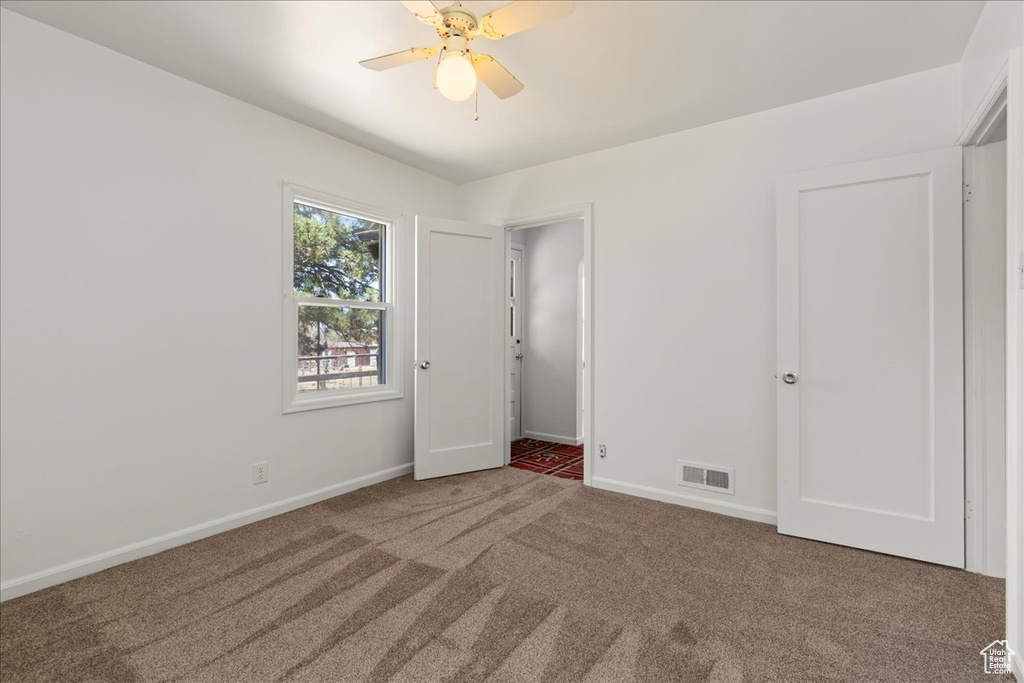 Unfurnished bedroom with carpet and a ceiling fan