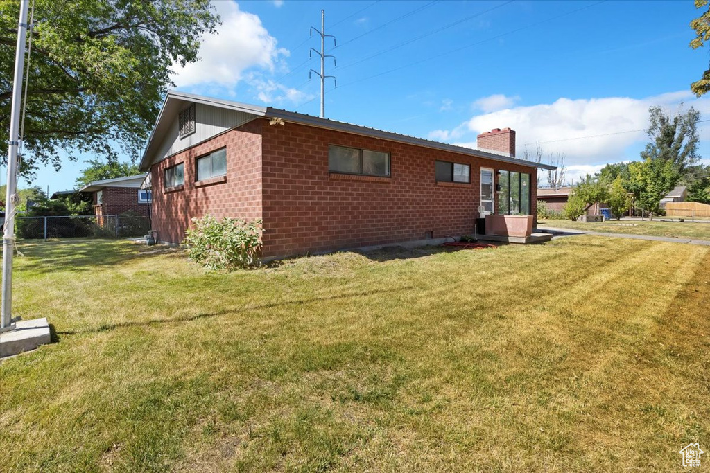 Back of property featuring a chimney and brick siding