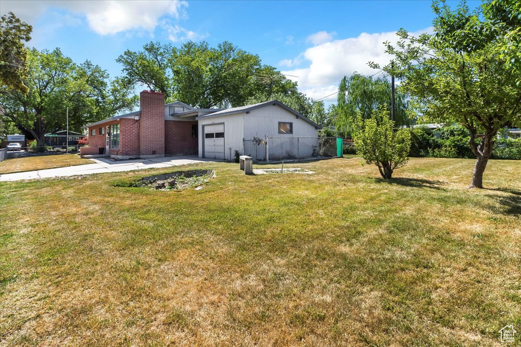 View of yard featuring an attached garage and driveway