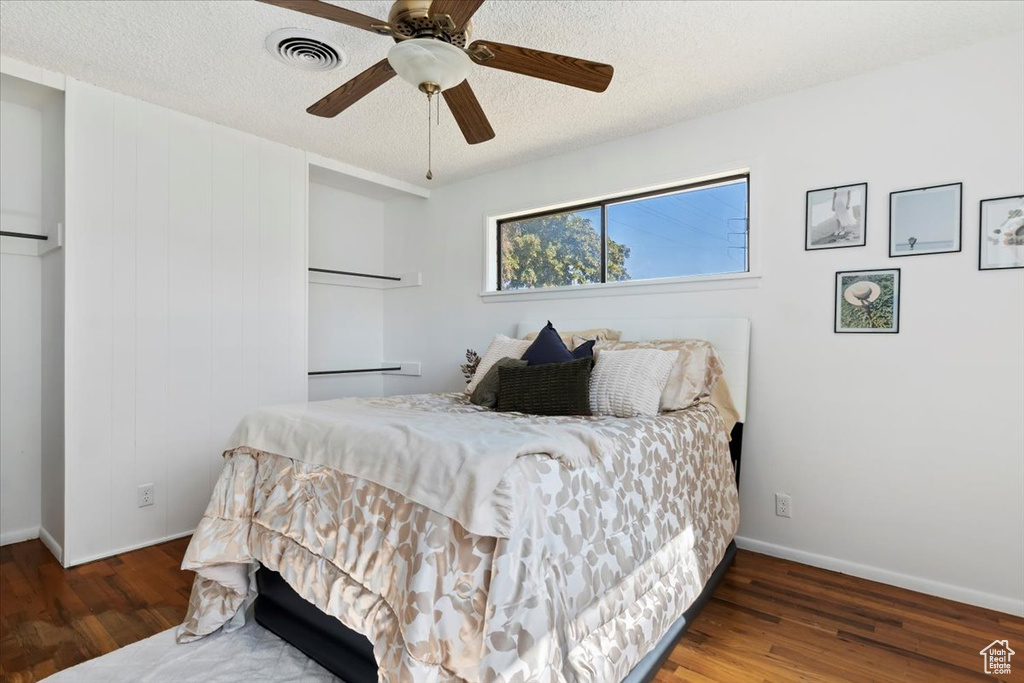 Bedroom featuring wood finished floors, a textured ceiling, and a ceiling fan