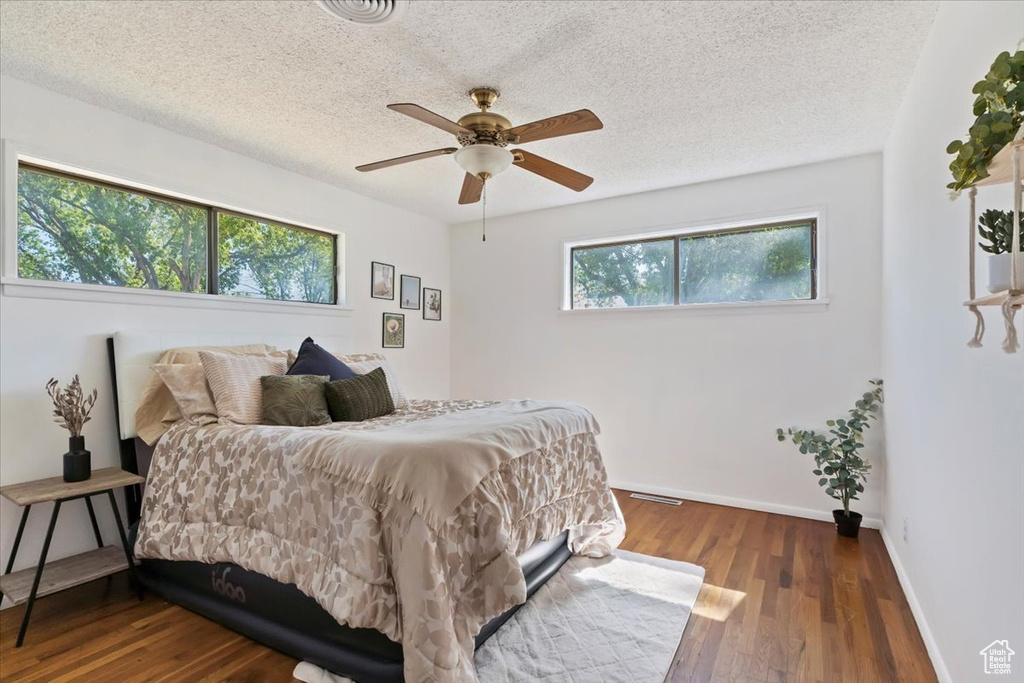 Bedroom featuring wood finished floors, a textured ceiling, and ceiling fan