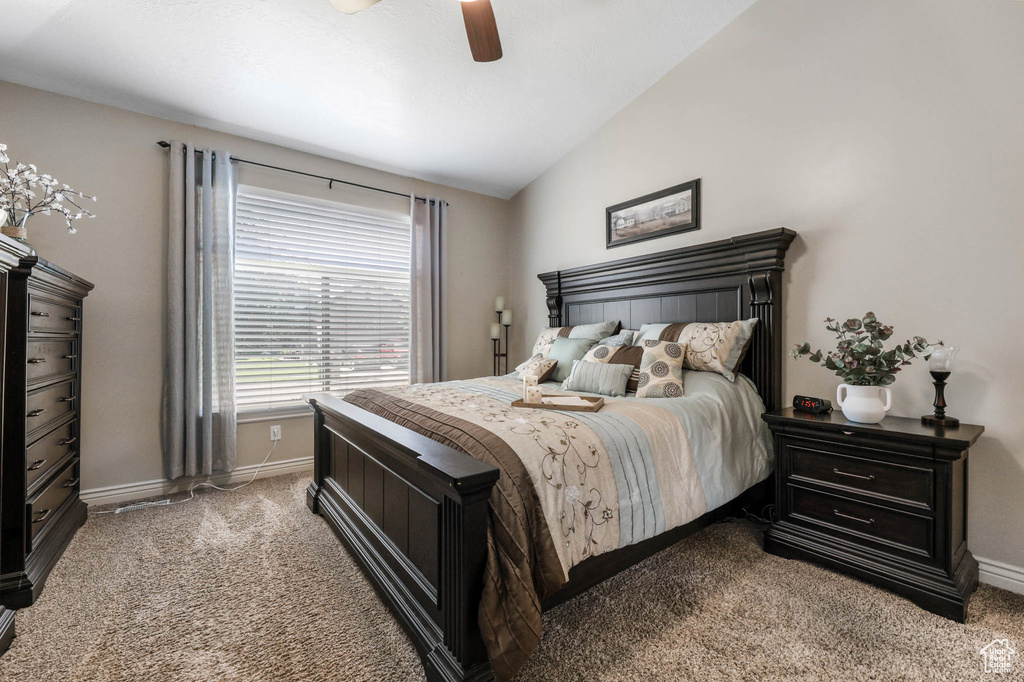 Carpeted bedroom with vaulted ceiling and ceiling fan