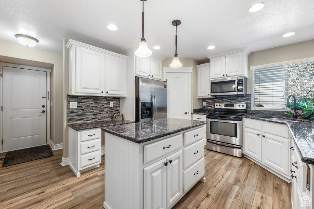 Kitchen featuring appliances with stainless steel finishes, white cabinets, light wood-style flooring, and recessed lighting