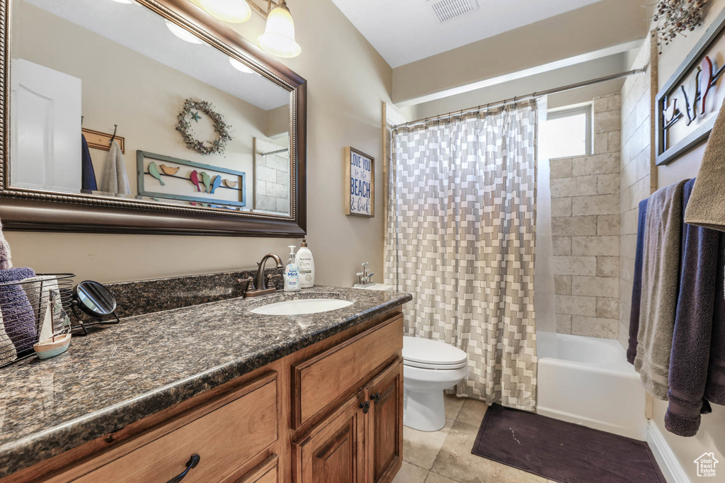 Bathroom with vanity, shower / bath combination with curtain, and tile patterned floors