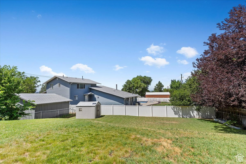 Fenced backyard featuring a storage shed