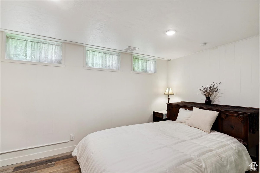 Bedroom with wood finished floors and baseboards