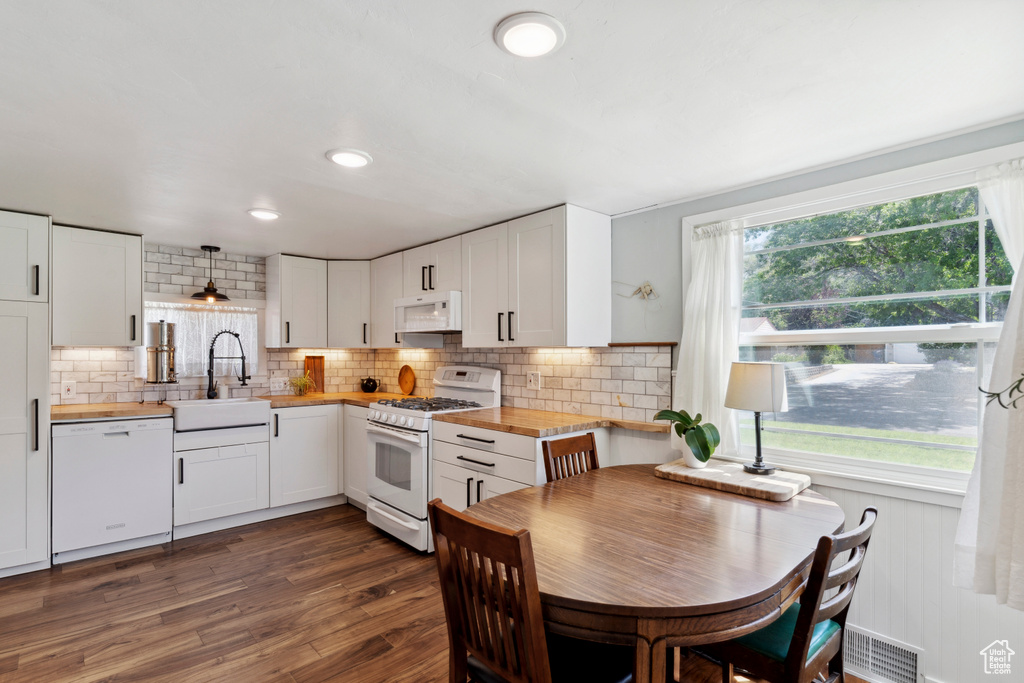 Kitchen featuring white appliances, butcher block counters, plenty of natural light, and white cabinets