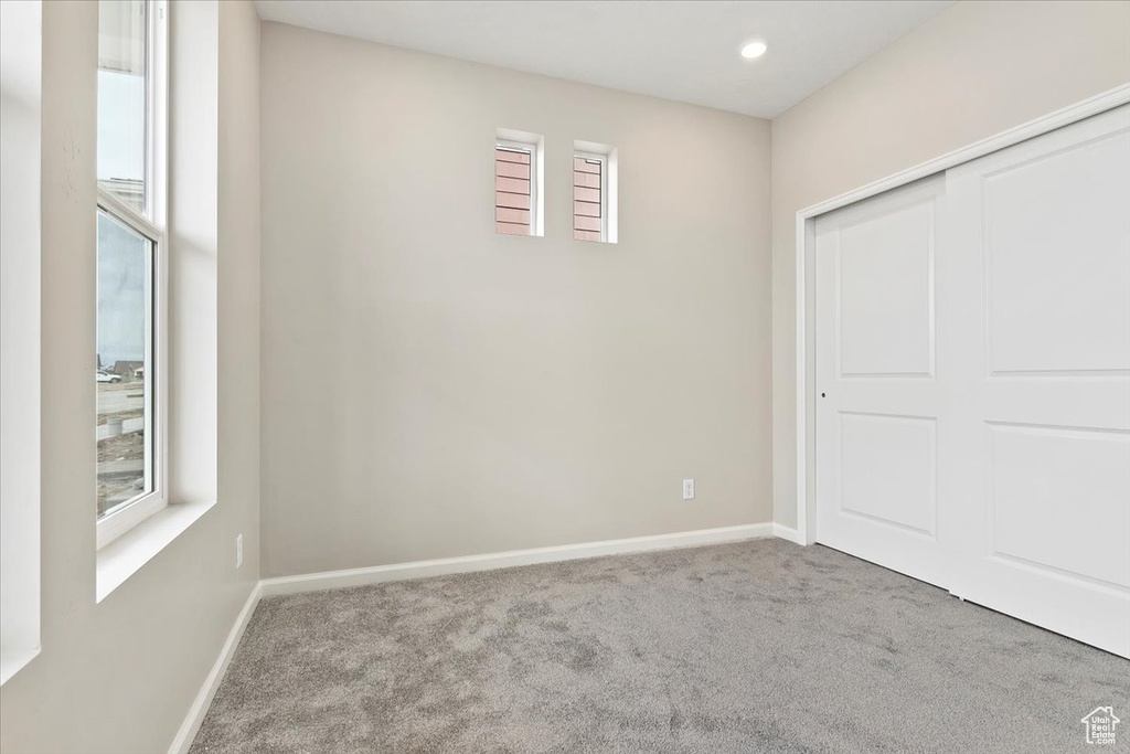 Unfurnished bedroom with carpet flooring, a closet, and recessed lighting