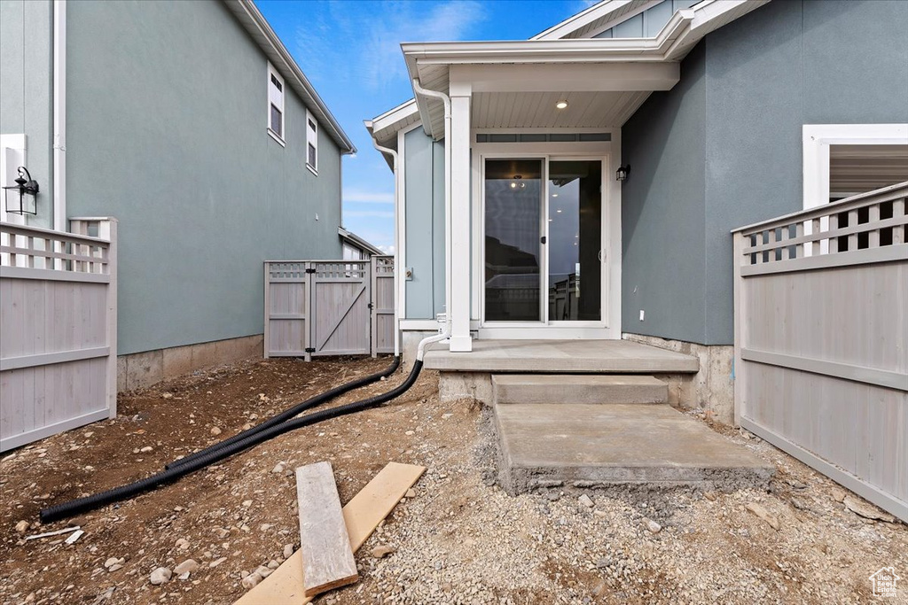 Property entrance featuring a gate and stucco siding