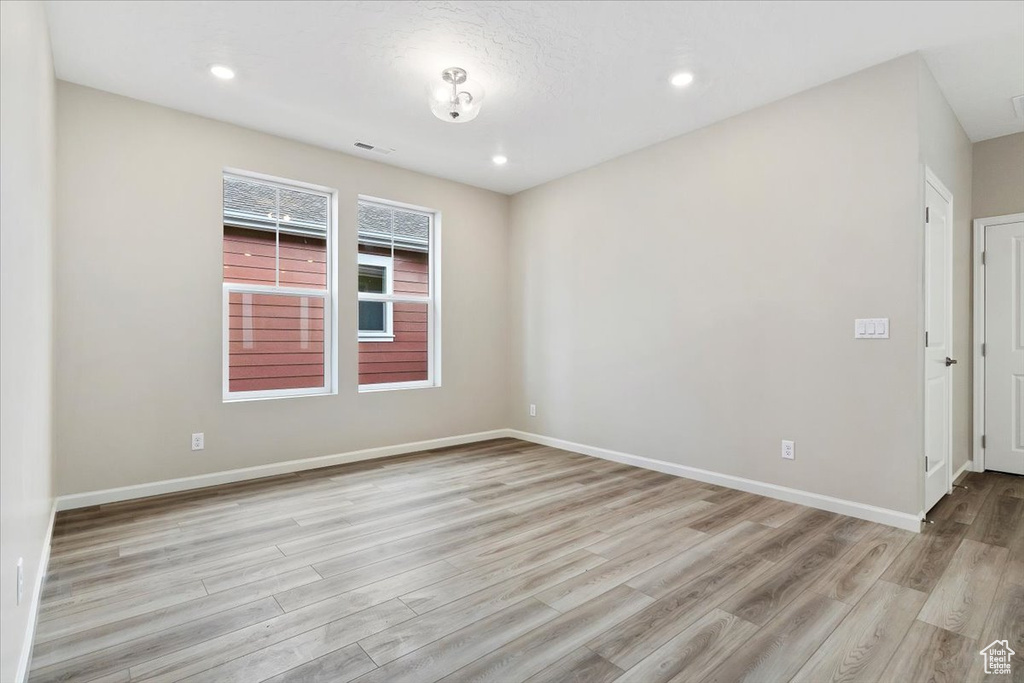 Unfurnished room with wood finished floors and recessed lighting