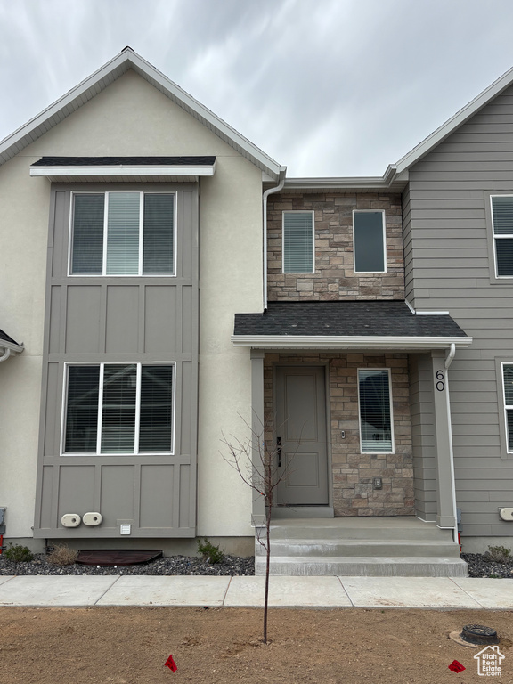 View of property with stone siding and stucco siding