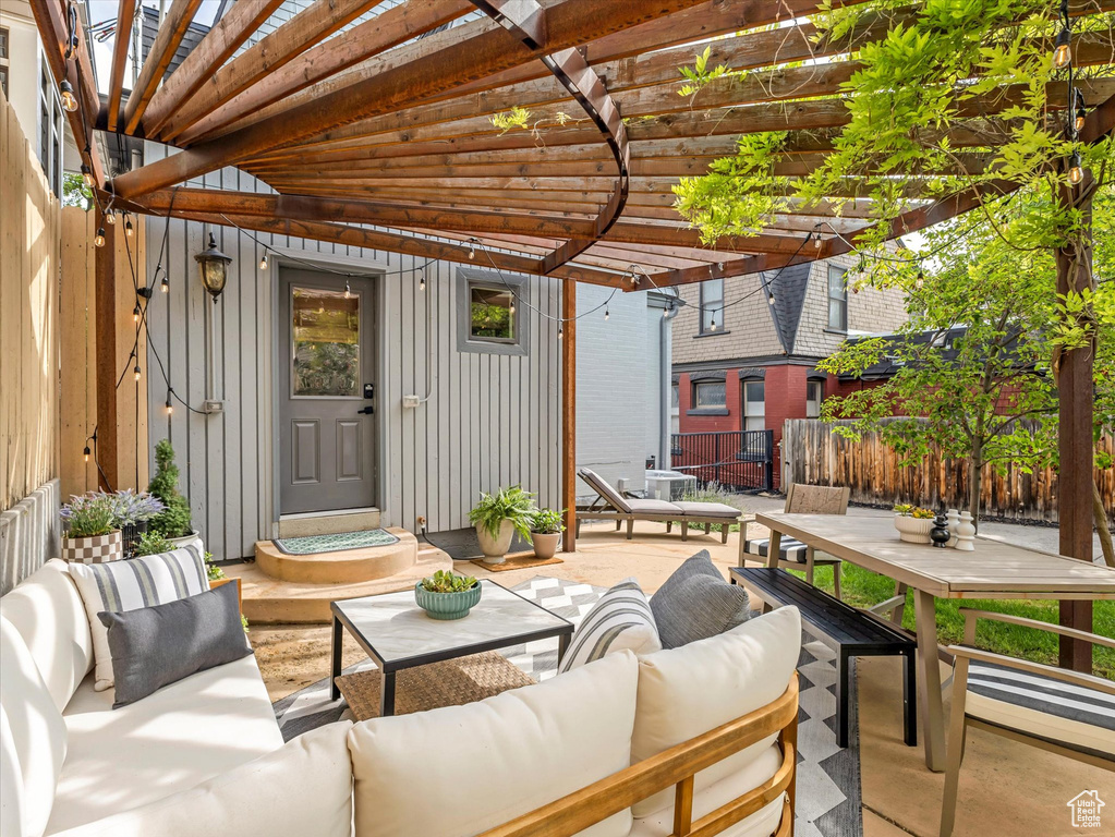 Fenced backyard with an outdoor hangout area, a pergola, a patio, and outdoor dining space