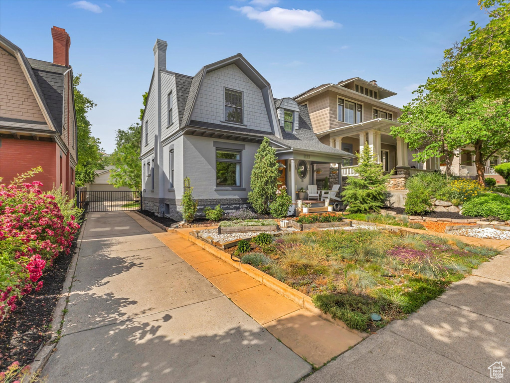 View of front of house with covered porch and a chimney