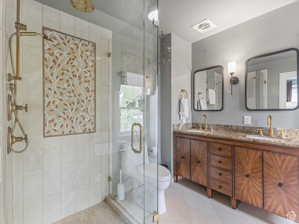 Full bath with double vanity, a shower stall, plenty of natural light, and tile patterned flooring