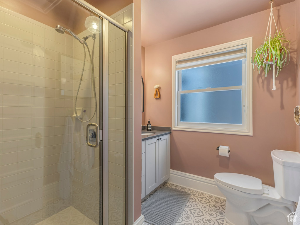 Full bathroom with vanity, a shower stall, and tile patterned floors