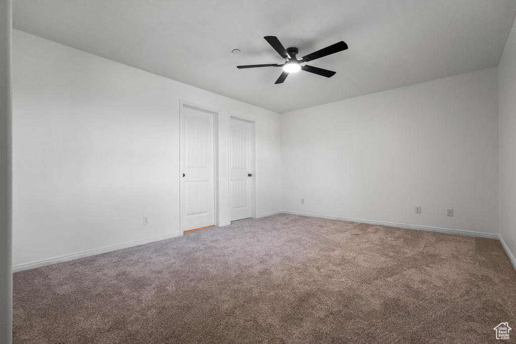 Unfurnished bedroom featuring carpet flooring and ceiling fan