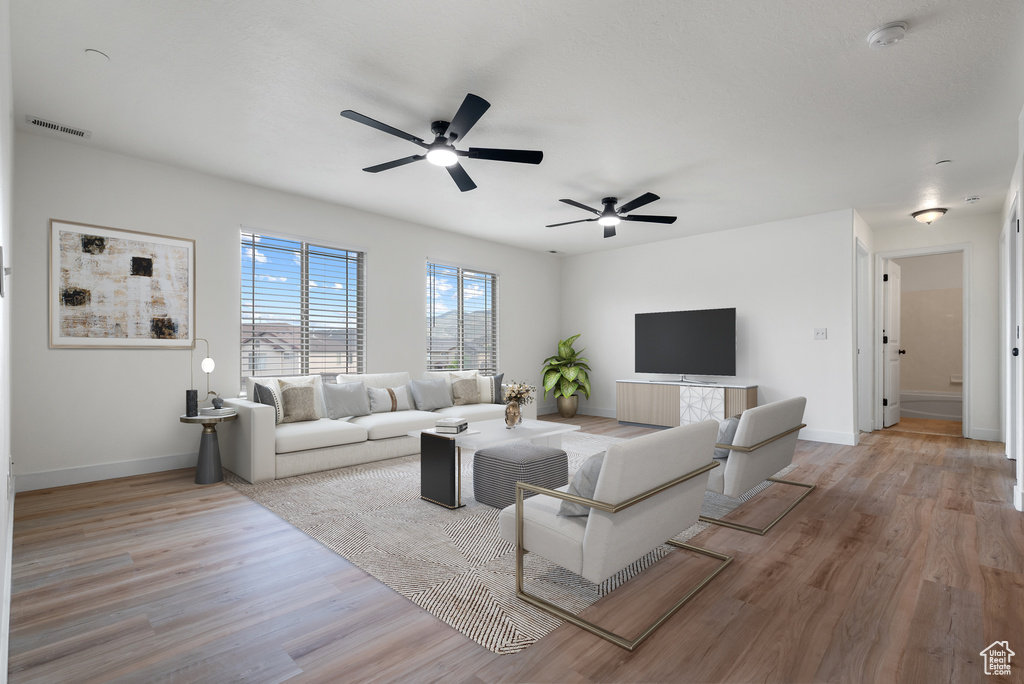 Living room featuring ceiling fan and wood finished floors