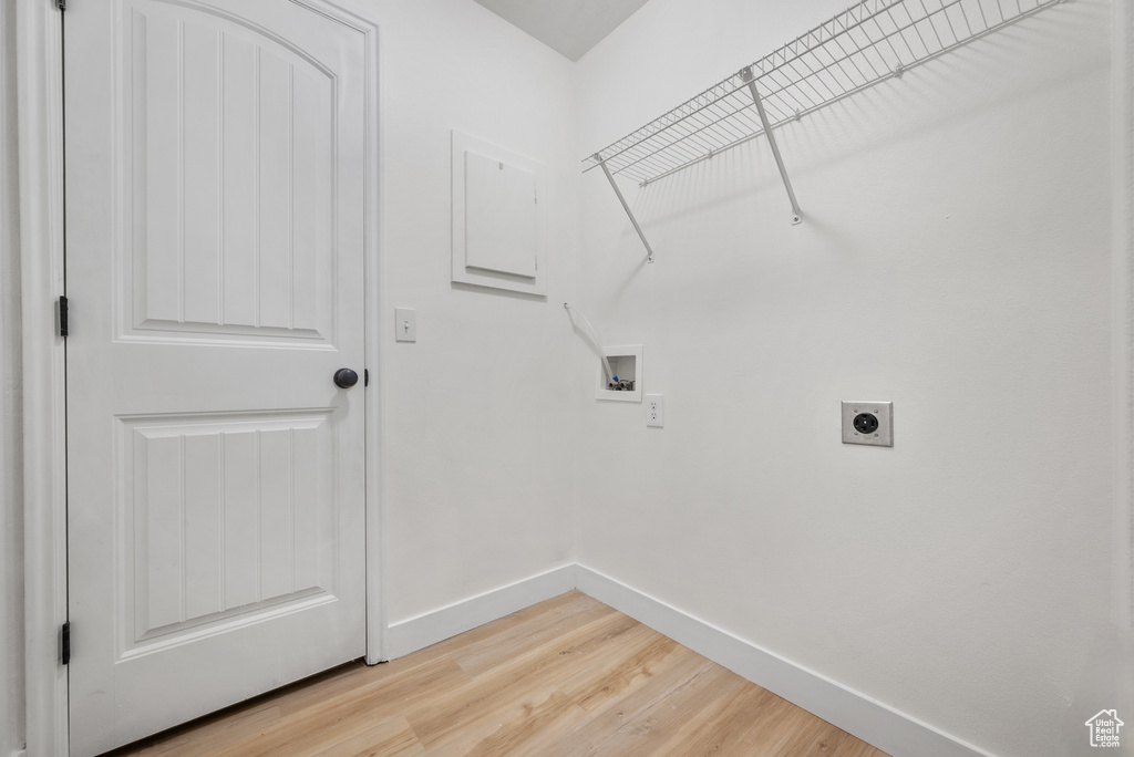 Washroom featuring hookup for an electric dryer, hookup for a washing machine, and light wood finished floors