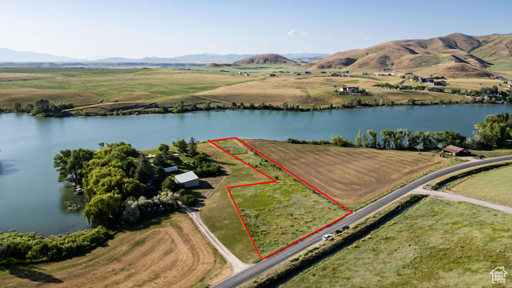 Aerial view of sparsely populated area with a water and mountain view and property parcel outlined