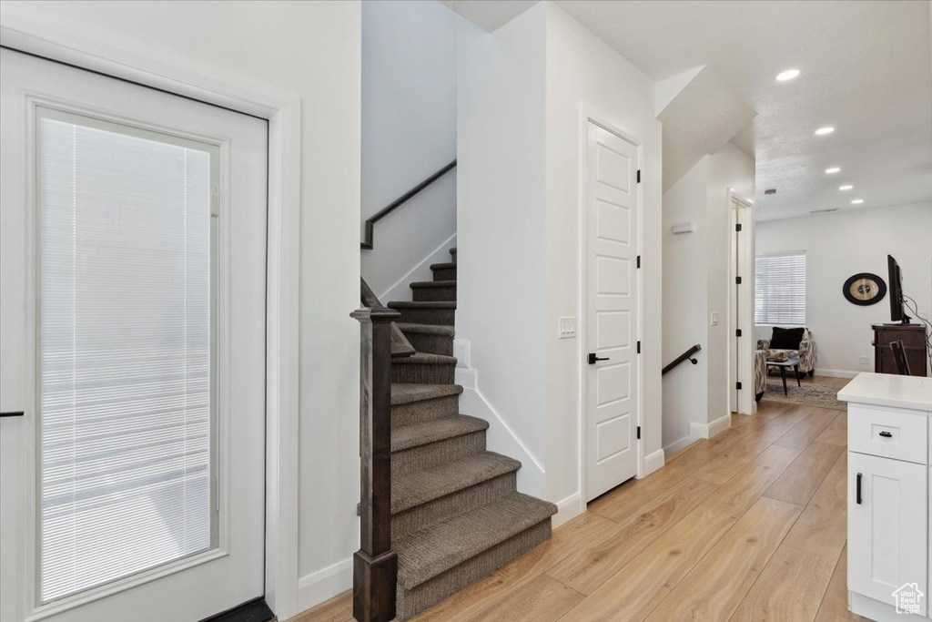 Stairs with hardwood / wood-style flooring and recessed lighting