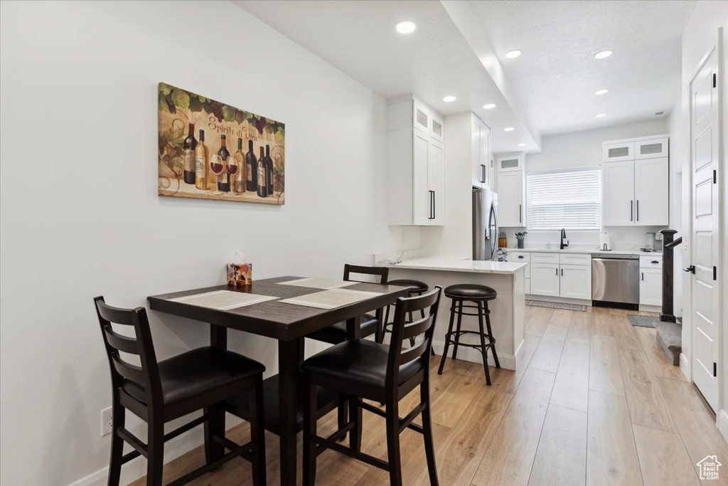 Dining space with recessed lighting and light wood-style flooring