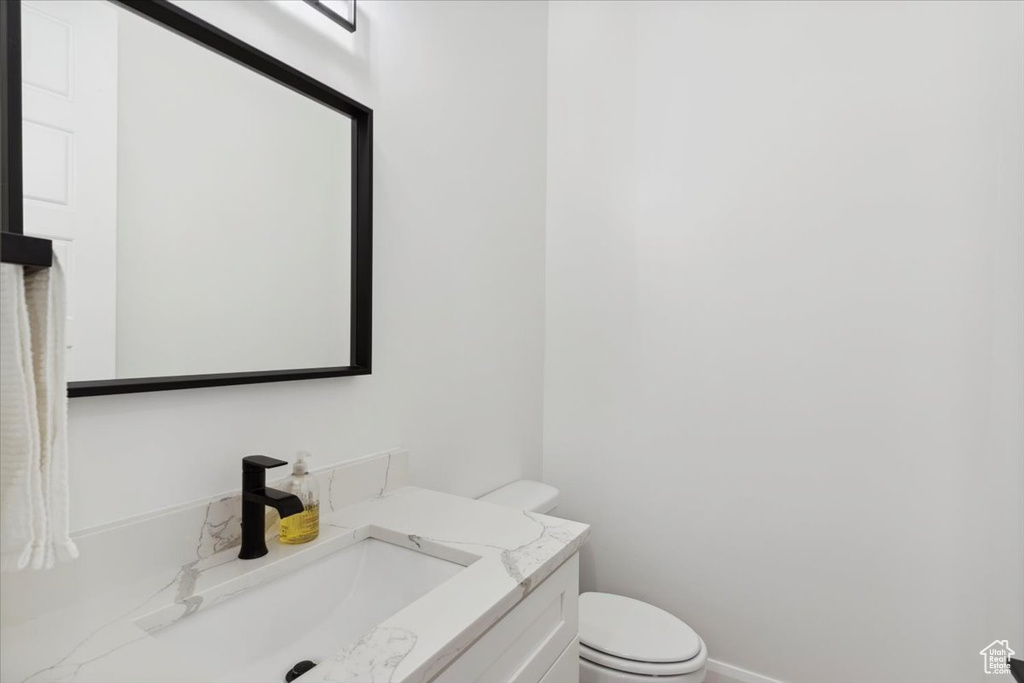 Half bathroom featuring toilet and vanity