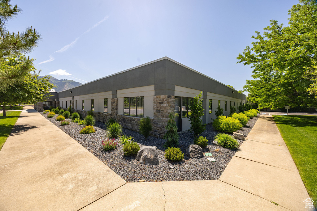 View of property exterior featuring stone siding and a mountain view