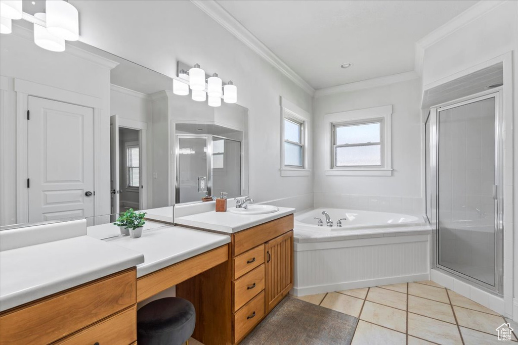 Bathroom featuring vanity, a stall shower, a garden tub, tile patterned flooring, and crown molding