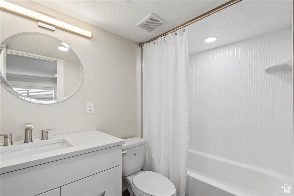 Full bathroom with vanity, shower / bath combo, and recessed lighting