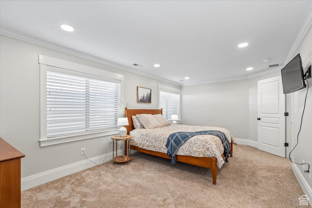 Bedroom featuring recessed lighting, ornamental molding, and light carpet