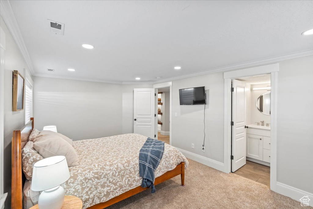 Carpeted bedroom featuring crown molding, recessed lighting, and ensuite bathroom