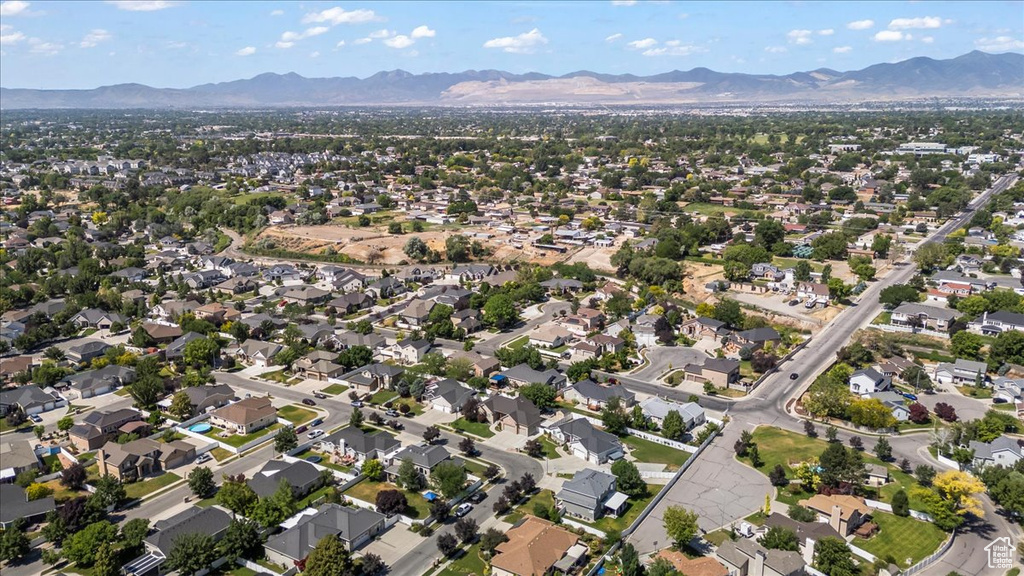 Aerial view of property's location featuring a mountain backdrop and nearby suburban area