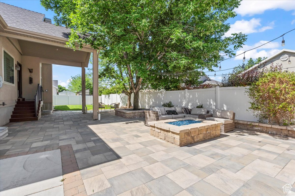 Fenced backyard featuring a fire pit and a patio area