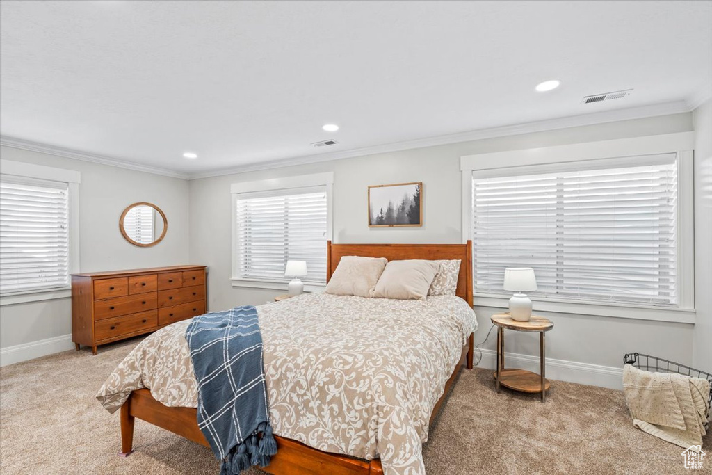 Carpeted bedroom with crown molding and recessed lighting