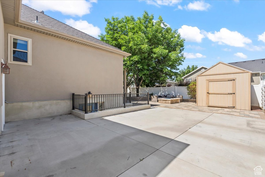 Fenced backyard featuring a patio area and a storage unit