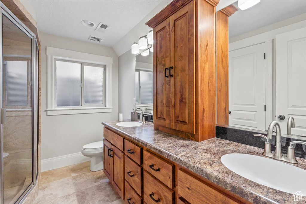 Full bathroom with double vanity and a shower stall
