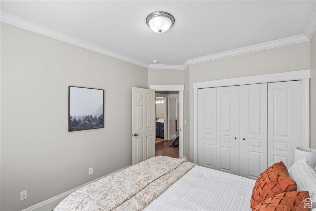 Bedroom with ornamental molding and a closet
