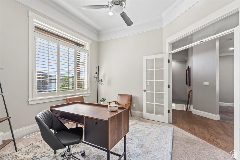 Carpeted office with ornamental molding, a ceiling fan, french doors, and wood finished floors