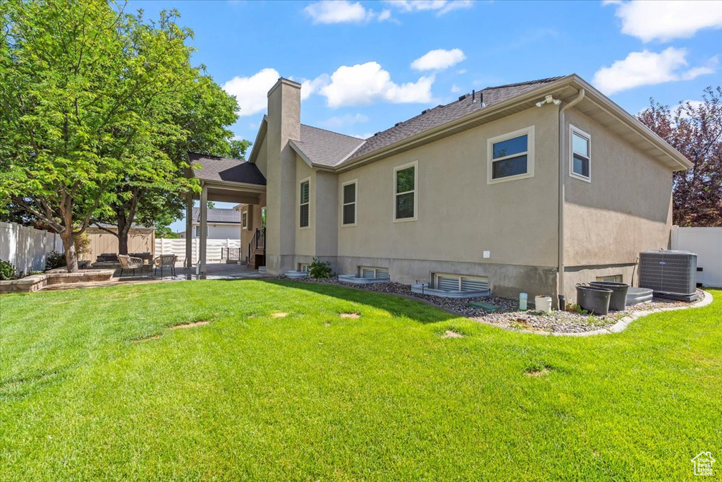 Back of property featuring a patio area, a chimney, and stucco siding