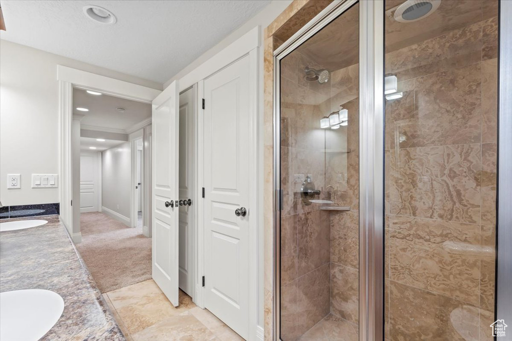Bathroom with a stall shower, double vanity, and recessed lighting