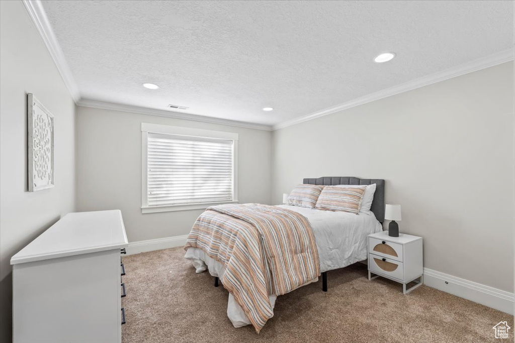 Bedroom with carpet, recessed lighting, ornamental molding, and a textured ceiling