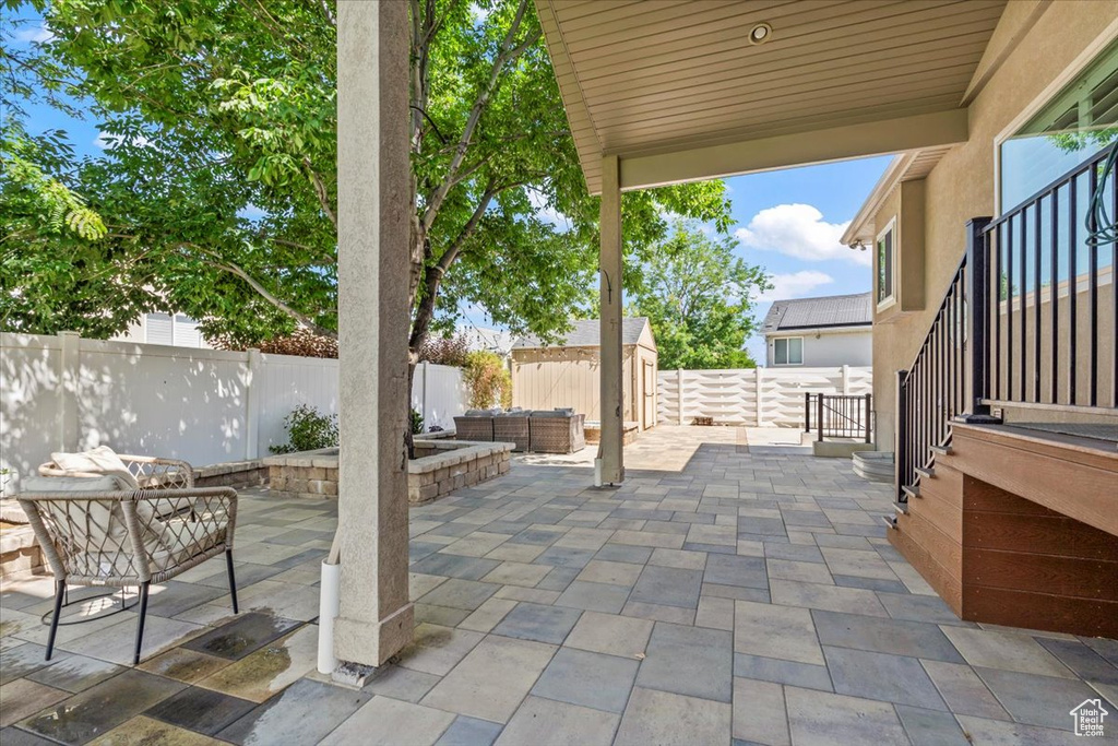Fenced backyard with a patio, outdoor lounge area, and a storage shed