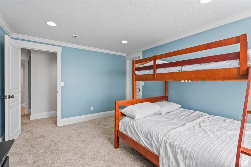 Bedroom with ornamental molding, carpet flooring, recessed lighting, and a textured ceiling