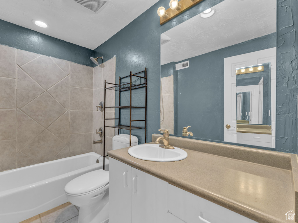Full bath featuring shower / tub combination, vanity, tile patterned flooring, and a textured wall