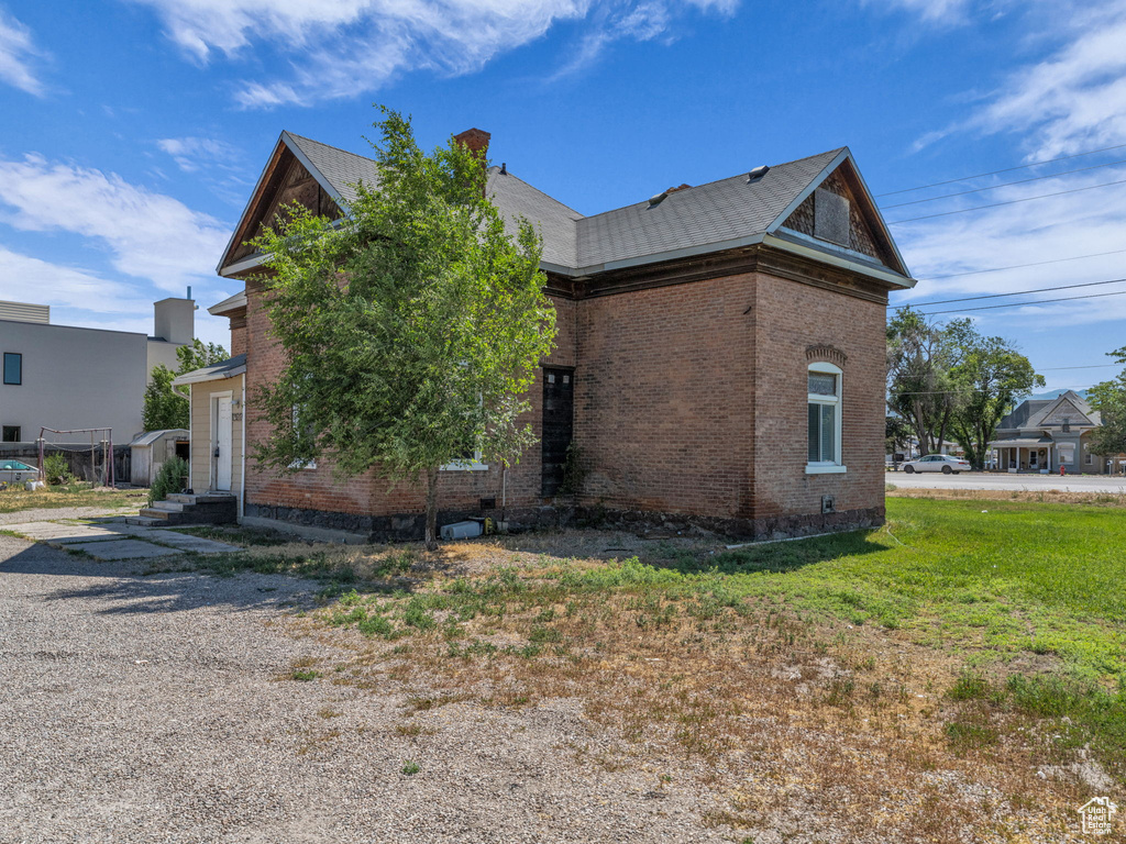 View of property exterior with brick siding and a chimney